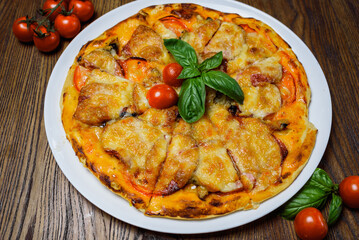 
pizza with meat and tomatoes under cheese