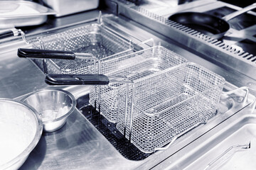 Friture cooker in restaurant kitchen, toned