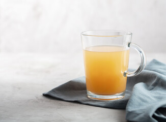 Homemade Beef Bone Broth in Glasses on a gray concrete background