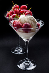Strawberry ice cream in martini glass on black background