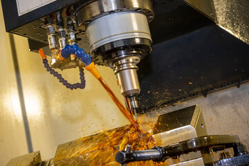 The CNC milling machine cutting the tire mold parts with liquid oil coolant method in vertical...