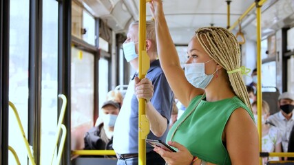 Coronavirus, covid -19, young woman with respiratory mask traveling in the public transport by bus