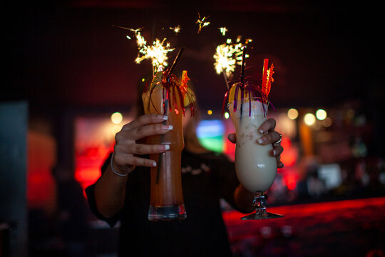 Cocktails mit Wunderkerzen in einer dunklen Bar