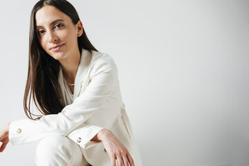 Photo of pleased businesswoman in jacket posing and looking at camera