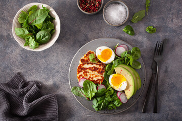 healthy keto paleo diet breakfast: boiled egg, avocado, halloumi cheese, salad leaves