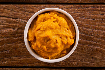 Pumpkin puree or hummus on a rustic wooden table. Selective focus