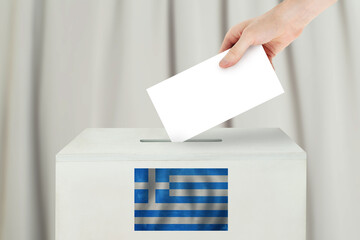 Greek Vote concept. Voter hand holding ballot paper for election vote on polling station