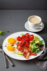 healthy keto diet breakfast: egg, tomatoes, salad leaves and bacon