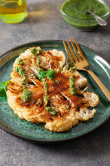 cauliflower steaks with herb sauce and spice. plant based meat substitute