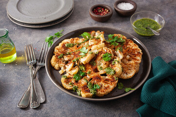 cauliflower steaks with herb sauce and spice. plant based meat substitute