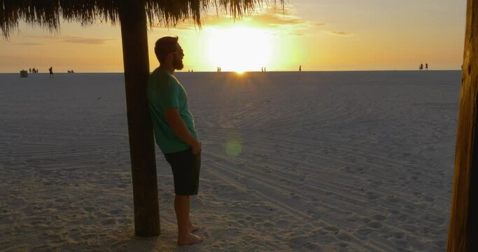 484 Man looking at people at the beach during the sunset