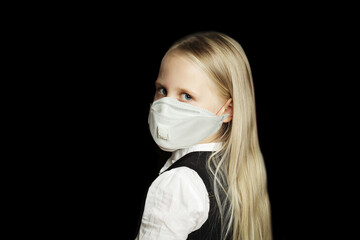 Little child girl student in protective medical mask on black background