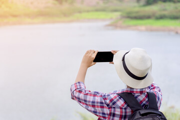 woman traveler with backpacker used smartphone to take a  photo