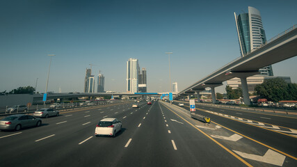 Sheikh Zayed Road in Dubai with car traffic in sunny day, United Arab Emirates.