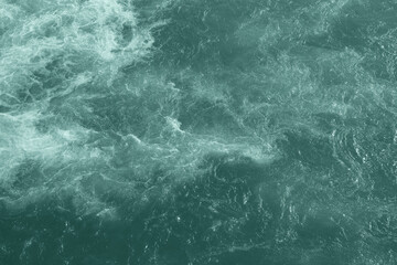 Fototapeta na wymiar The raging waters of the river Ganges in Rishikesh. Top view of the raging elements. White foam on blue water.