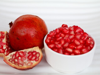 Fresh red color pomegranate fruit  and kernels in a white background