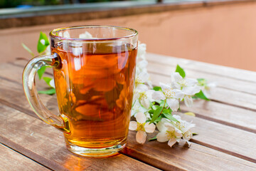 Herbal tea with flowers on rustic wooden table. Summer tea menu.