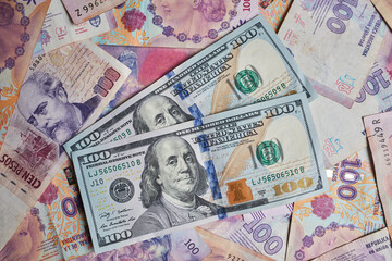 Fototapeta na wymiar Dolars and Argentinian Pesos