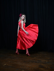 beautiful girl in evening red dress posing on a black background