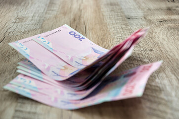 new banknotes of 200 hryvnia denomination on a wooden background. Ukrainian money. Business concept.
