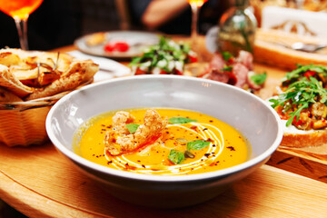 Deep plate with pumpkin soup, Italian restaurant, toned