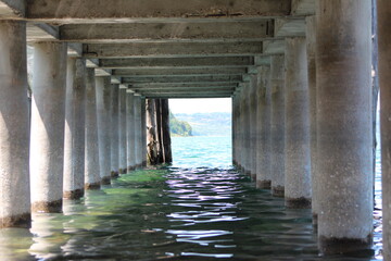View under the dock at the beach Lake Bracciano , Anguilla Sabazia Marina,(RM)Italy,Coming the calm waves under the dock.