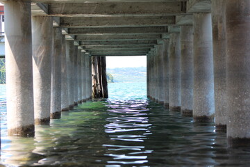 View under the dock at the beach Lake Bracciano , Anguilla Sabazia Marina,(RM)Italy,Coming the calm waves under the dock.