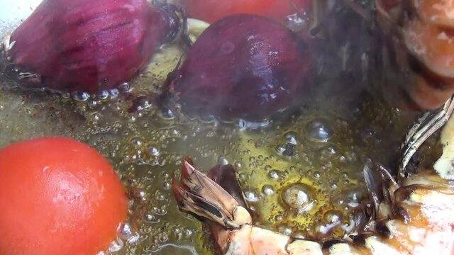 Close up shot a of ca ooking tiger prawn being turned over to its other side