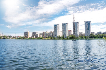 Obraz premium A beautiful view of the lake in the city of Kiev with modern skyscrapers and a beautiful lake. The view from the shore. Ukraine, Kiev.