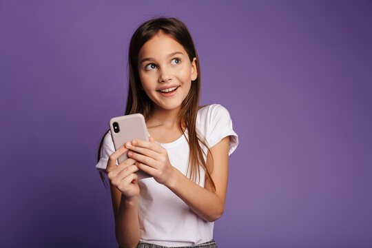 Photo of smiling attractive girl using mobile phone and looking aside