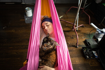 young woman in a hammock with a cat
