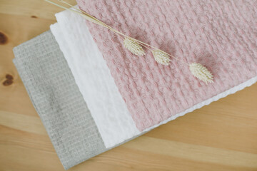 Pile of clean linen cotton towels on kitchen table. Pastel colors. Food photo. Natural linen cotton...