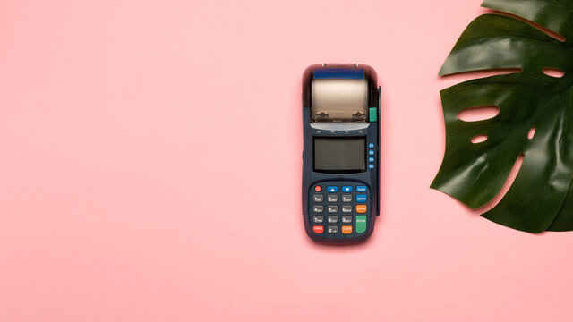 NFC payment contactless terminal on a pink background. Credit card or phone pay pos banking device, card machine.