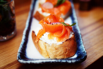 Salmon slices and creamy cheese on bread, set of bruschettas, toned