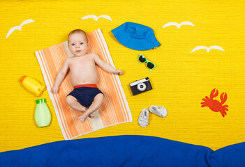 Obraz na płótnie Canvas Funny kid is lying on a sandy beach. Beach and sea. Summer vacation