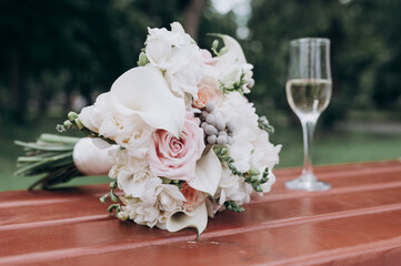 bouquets of flowers and a glass of champagne on a bench in the Park