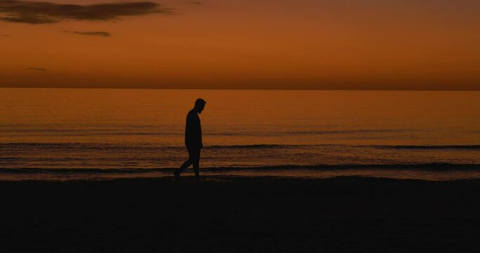 499 Silhouette of a man walking in the water after the sun has set