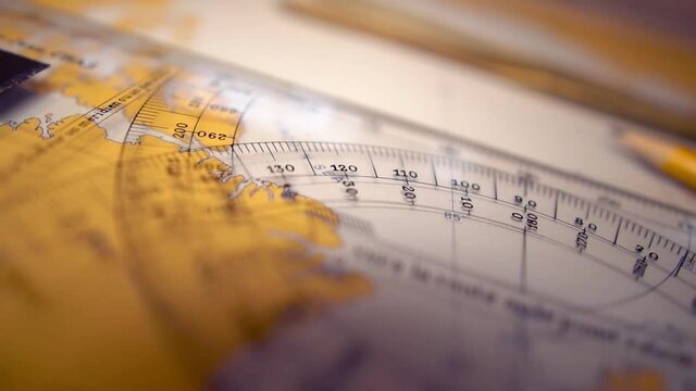Plotting position on navigational chart at sea. Marine Map and ruler. Sowmotion shot
