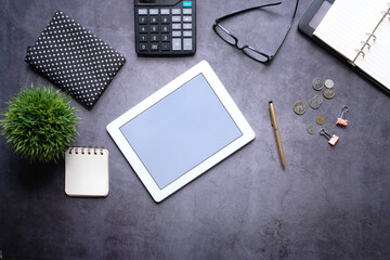Flat composition of digital tablet and office stationary on black background 