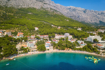 Amazing aerial view of Makarska riviera, Dalmatia, Croatia. Daytime landscape of popular tourist resort on the Adriatic sea coast at the foot of the rocky Dinara mountains, outdoor travel background