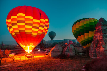 Hot air balloons at sunrise preparing for flight.