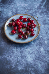 High angle view of freshly picked cherries on a stone surface with copy space