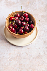 High angle view of freshly picked cherries on a stone surface with copy space