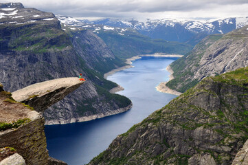 Girl sitting on the rock Trolltunga in Norway