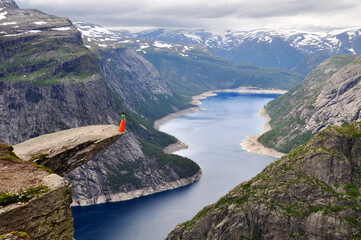 Girl standing on the rock Trolltunga in Norway