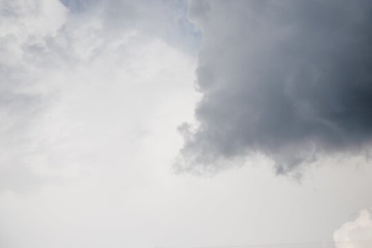 One Dark Gray Cloud On Pale Grey Sky Background