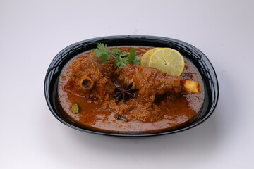 Mutton curry or Lamb curry,arranged in ablack vessel with white background