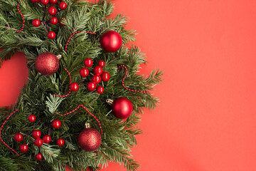 Christmas composition. Christmas ring or wreath on the red background. Top view. Copy space.