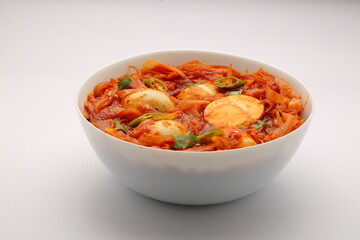 Egg roast or masala,reddish dish arranged in awhite bowl with white background