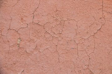 old cracked pink wall, requiring plaster repair and paint